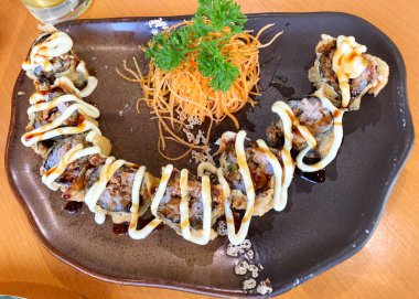 Fried Sushi roll. This sushi is filled with tuna, fried in tempura and sprinkled with brown sauce and mayonnaise. It tastes good and crispy.