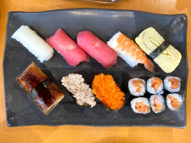 Assorted sushi nigiri and maki big set on slate. A variety of Japanese sushi with tuna, crab, salmon, eel and rolls. top view.