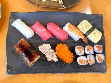 Assorted sushi nigiri and maki big set on slate. A variety of Japanese sushi with tuna, crab, salmon, eel and rolls. top view.