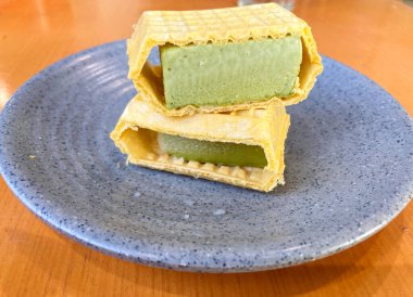 Waffle Ice Cream Sandwich, green tea flavour, served on a plate. a dessert after meal.