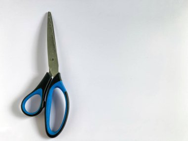 Blue and black scissors isolated on grey background. Copy space.