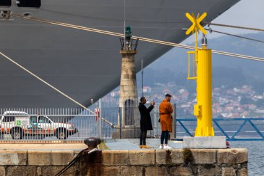 Vigo, İspanya - 24 Nisan 2020: İnsanlar etkileyici MSC Preziosa yolcu gemisinin altında rıhtımda