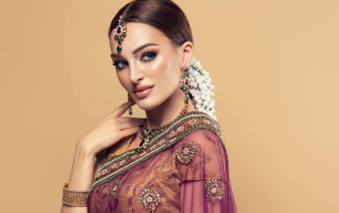 Güzel Hintli bir kızın portresi. Kundan mücevher seti olan genç Hintli kadın model. Geleneksel Hint kostümü lehenga choli veya sari