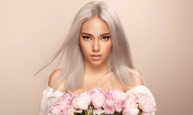 Güzel Asyalı kadın, saç boyalı, aşırı sarışın. Güzellik salonunda yapılan şık bir saç stili. Moda, kozmetik ve makyaj