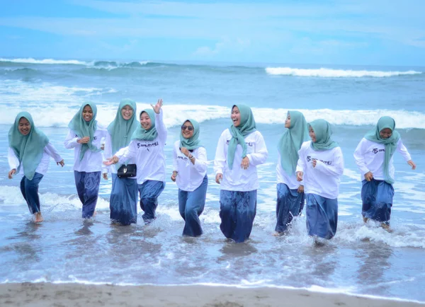people playing in the water while on vacation at the beach, parangtritis yogyakarta, 18 maret 2022