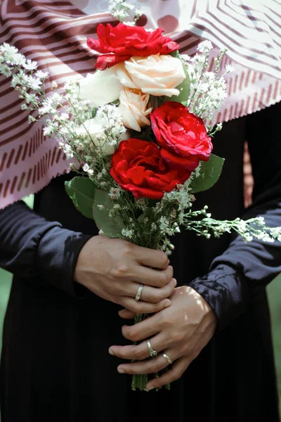 hand holding flower red