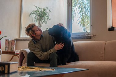 Erkek ve erkek, evlerinin oturma odasında pencerenin önünde ve koltukta otururken aynı hassas anı paylaşıyorlar..