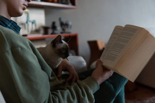 Άντρας Κουβαλάει Γάτα Του Που Κοιτάζει Βιβλίο Στα Χέρια Του — Φωτογραφία Αρχείου