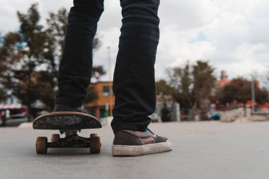 Tennis feet on a skateboard with the park in the background