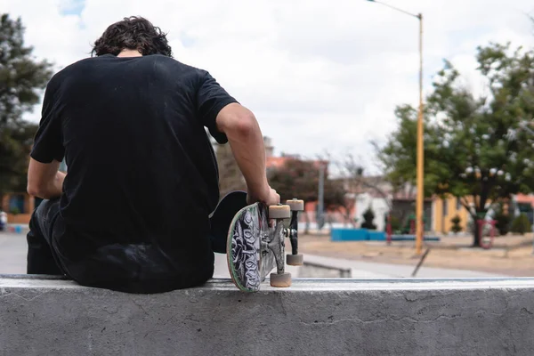Menino Parte Trás Usando Uma Camiseta Preta Segura Seu Skate — Fotografia de Stock