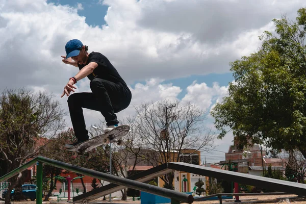 Bruslař Oblečený Černém Čepicí Vzduchu Zatímco Padá Svým Skateboardem Trubice — Stock fotografie