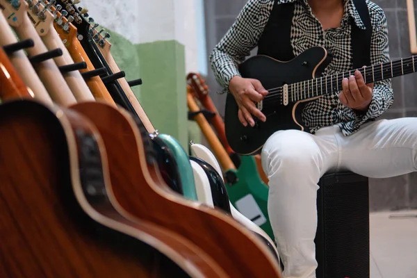 Many Electric Acoustic Guitars Stand Foreground Musician Playing Background Body — Zdjęcie stockowe