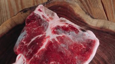 Panning of a piece of raw frozen meat on a wooden base. High quality 4k footage. Panning of a piece of raw frozen meat on a wooden base. Raw meat in excellent condition. Thin cut top sirloin beef. Red