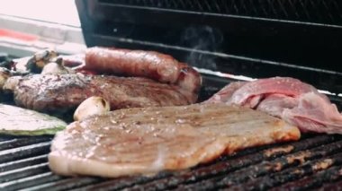 Izgara sigara ve üzerine tortilla koyan bir el. Izgara dolusu nopales, soğan ve ızgara et. Izgara ve yemeğin detaylı planı..