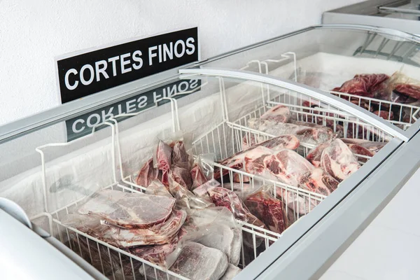 Refrigerator with fine cuts of meat in a butcher shop. Different types of meat cuts. Top Sirloin. Raw meat.