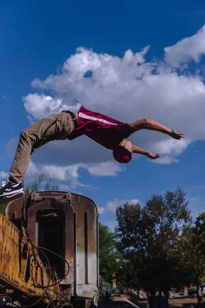 Hispanic Man Dressed Red Urban Clothing Doing Somersault Abandoned Train — Fotografia de Stock