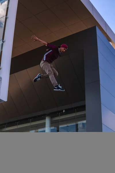 Latino Man Dressed Urban Clothing Jumping Top Building Architecture Background — Stock fotografie