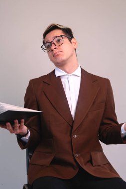 Elegant man with resigned expression. A man in a brown suit, white shirt and glasses. Man in a suit making a confused expression. High quality photo