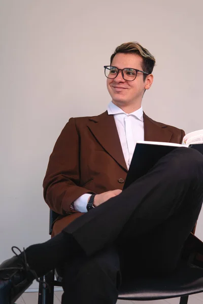 A college professor in a suit sitting down smiling. Happy lawyer on a white background. A businessman with a pleased expression. Elegant man smiling. High quality photo