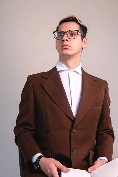 Business man on a white background. Man dressed in brown jacket and glasses. Blond Caucasian intellectual man. Elegant man on isolated white background. High quality photo