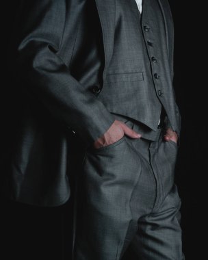 Gray suit on a black background. Man dressed in a jacket and elegant pants on a black background. High quality photo