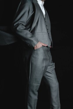 Businessman with his hands on the bag. Gray suit with jacket and pants. Elegant man modeling a gray colored jacket. High quality photo