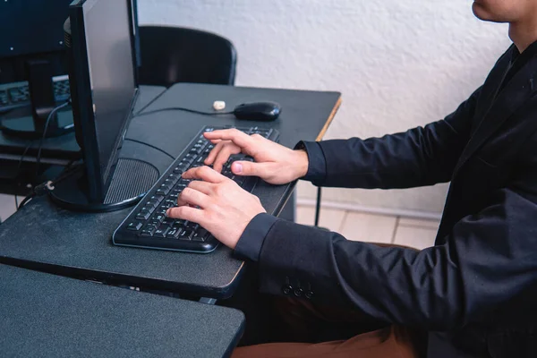 Man typing on the computer in his office. Close up of a workers hands at a desk typing. High quality photo