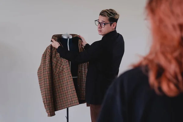 Man viewing a suit on a mannequin. Clothing designers working on a yellow jacket. Designer working on a bag that he shows to his clients. High quality photo