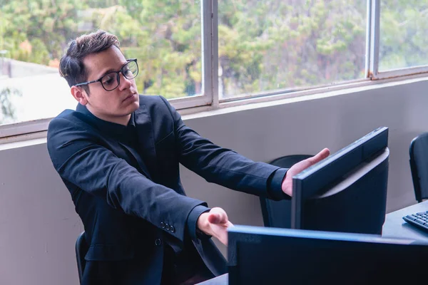 Surprised man about to finish his work on the computer. Surprised businessman with what he saw on the monitor. Office with computers by a window. High quality photo