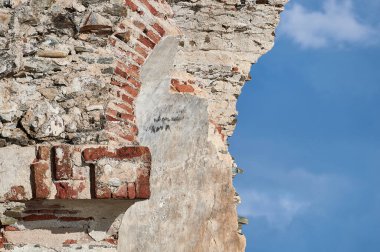 Terk edilmiş ve yok edilmiş ortaçağ kulesi iç kısımları, mavi gökyüzü ve beyaz bulutlar.