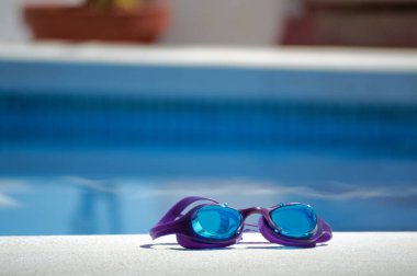 Güneşli bir günde havuza dalmak için mavi gözlükler..
