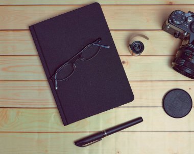 Preparation of session with old camera, film and a pen on a closed notebook