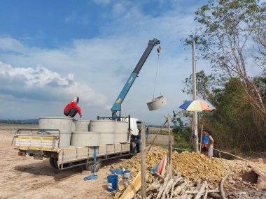 Bir vinç inşaat alanındaki beton boruları kaldırıyor. Nan, Tayland. 22 Mayıs 2022