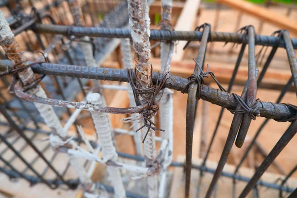 Steel rebar framing with hand wire are tying the beam steel for building in construction site. Construction work. Selective focus.