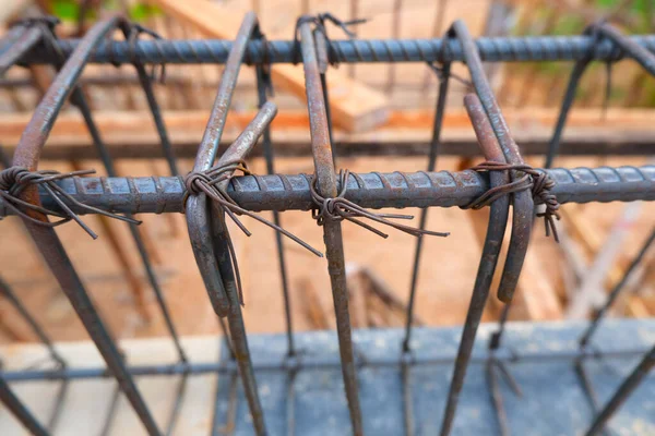 Steel rebar framing with hand wire are tying the beam steel for building in construction site. Construction work. Selective focus.