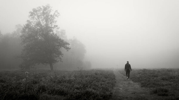 Black and white moody photo in nature with a lonely person
