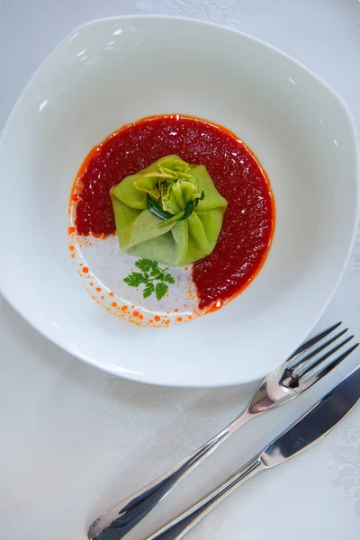 Domates soslu yeşil hamurla doldurulmuş hamur işi.