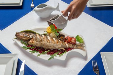 Kızarmış balık turna balığı dilimlenmiş, garnitür nar sosuyla iyi kızartılmış.