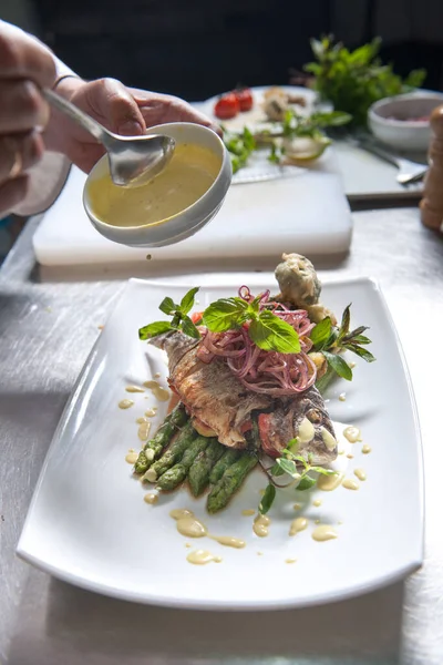 chef prepares fish for Dorado