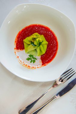 Domates soslu yeşil hamurla doldurulmuş hamur işi.