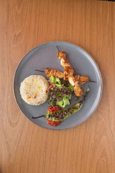 Chicken kabab with hot pepper rice garnish and tomato salad