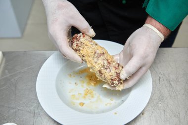 Ekmek kırıntıları içinde mozzarella peyniri ve mantarla doldurulmuş etli pirzola rulosu.