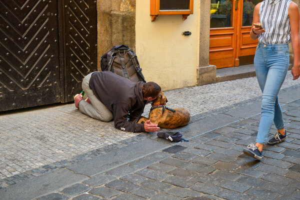 Бродяга с собакой просит денег на еду в центре Европы, Праге