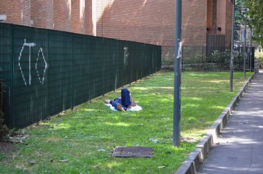 Center of Milan, Italy, a worker lies on the lawn and rests in the afternoon