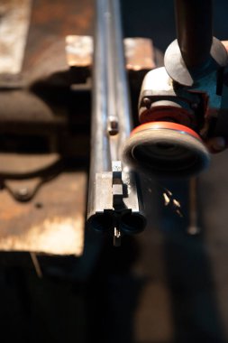 Baku Azerbaijan weapons workshop grinding by a grinder preparing a gun barrel for burnishing