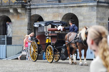 Amsterdam city center driver polishing the carriage to a shine prepares for customers a happy driver