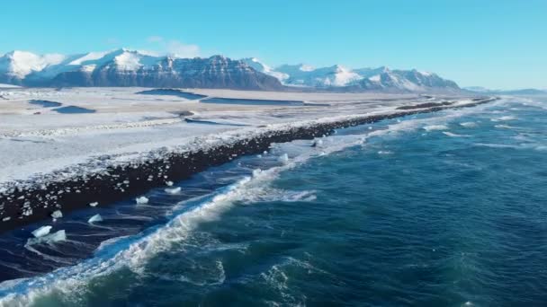 Paisaje helado, costa cubierta de nieve y témpanos de hielo en la playa Diamond de Islandia. Winter and Permafrost, Concept of Global Warming. 4k Aerial Drone disparo — Vídeos de Stock