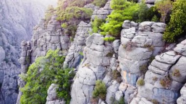 Muazzam Muhteşem Kayalar, ünlü Dağlar Vadisi üzerinde destansı hava aracı uçuşu, devasa taş yapılar, yeşil ağaçlı dramatik jeolojik harikalar. Kuş bakışı manzara 4k