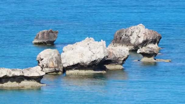 海蓝色的海水和岩石，阳光明媚的白天的海景，惊人而壮观的海浪冲击着海岸的岩石，造成了水波的爆发 — 图库视频影像