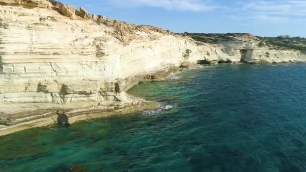 Vista superior aérea de Seashore, Mar com montanha, penhasco rochoso íngreme, bela paisagem turística. Falésias brancas na costa do turquesa Oceano drone 4k tiro. Ondas de água batendo contra a rocha — Vídeo de Stock